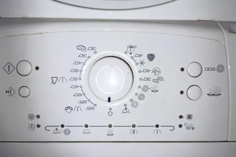 Panel sterowania pralki Whirlpool z ikonami programów i temperatur. Pomoc w obsłudze urządzenia.