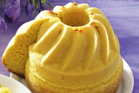 Żółty, puszysty babka wielkanocna, ozdobiona szafranem, wygląda jak bardzo stare ciasto wielkanocne.