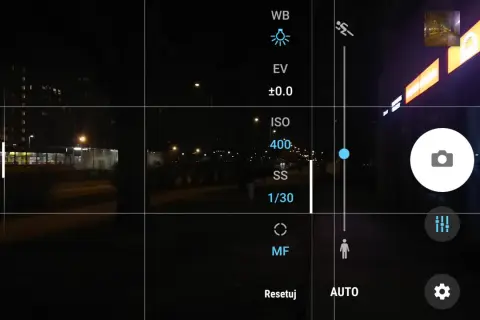 Ekran telefonu z widokiem nocnym. Ustawienia aparatu pokazują, jak ustawić długie naświetlanie, z widocznym ISO 400 i czasem 1/30s.