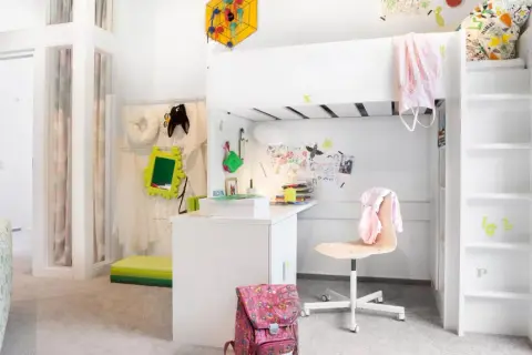 Ein kleines Kinderzimmer, perfekt eingerichtet für ein Schulkind. Ein Hochbett, Schreibtisch und viel Platz zum Spielen und Lernen.