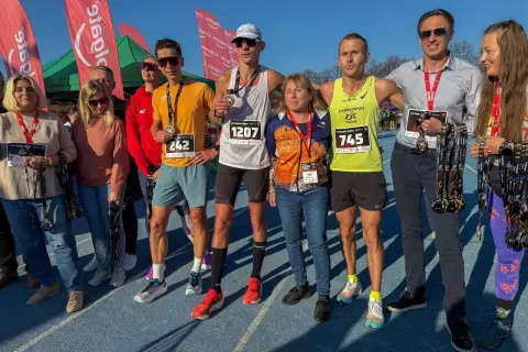 Uczestnicy biegu z medalami, zastanawiają się co zjesc przed biegiem, by osiągnąć sukces.