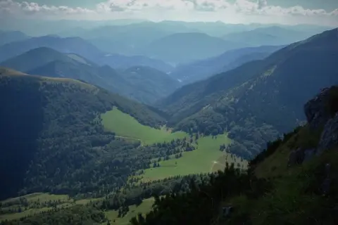 Malownicza dolina w Małej Fatrze, zielone łąki i lasy, idealne na szlaki.