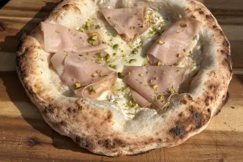 Neapolitanische Pizza Rezept: Köstliche Pizza mit Mortadella, Pistazien und cremiger Käsesauce.