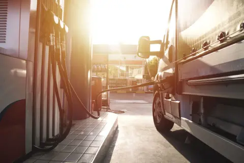 Lastenbilen tankas med diesel i solnedgången. En gammal dieselmotor behöver sin energi.