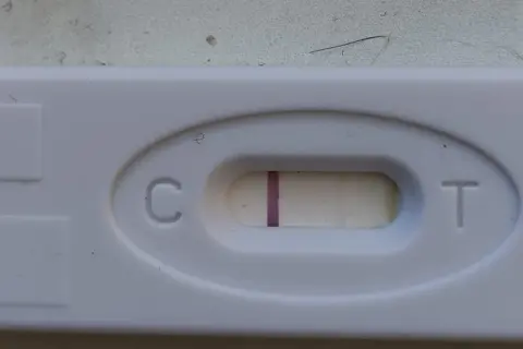 Test ciążowy z widocznym zarysem drugiej kreski. Czekam na cud.