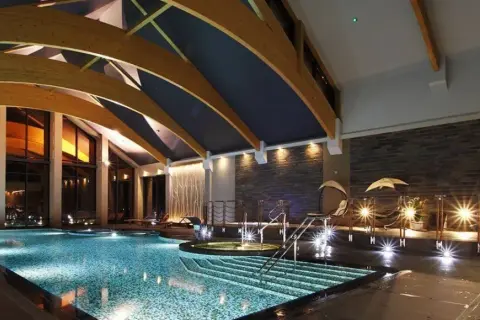 Luksusowe hotele na Mazurach z basenem oferują relaks w nowoczesnym stylu. Wnętrze basenu z podświetlanymi schodkami i jacuzzi.