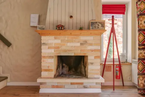 Ein Kamin aus Sandstein, der gereinigt wurde, mit Holzverkleidung und Dekorationen.