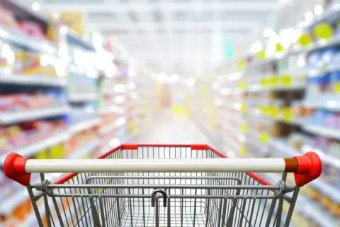 Wózek sklepowy w alejkach pełnych produktów. Z aplikacją blix zakupy stają się prostsze i szybsze.