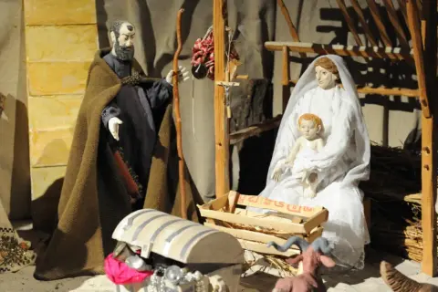 Krippenszene mit Maria, Josef und Jesuskind. Die Szene erinnert an die Ursprünge von Weihnachten.