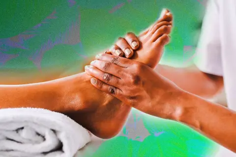 Mains massant un pied, évoquant la réflexologie plantaire colonne vertébrale pour un bien-être total.