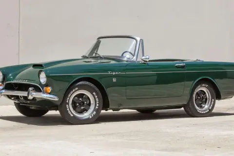 En grön Sunbeam Tiger cabriolet, en klassisk sportbil, står parkerad.