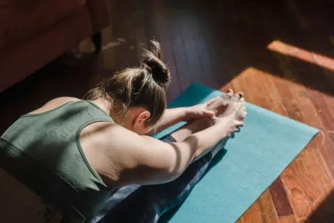 Mujer en postura de yoga, buscando el samadhi significado en la quietud.