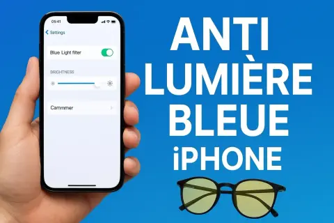 Une main tient un iPhone affichant le filtre anti lumière bleue activé. Des lunettes jaunes sont posées à côté.