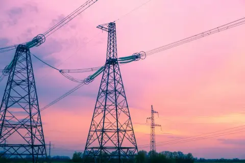 Wieże energetyczne na tle różowego nieba. To jak definicja częstotliwości, która opisuje cykliczność zjawisk.