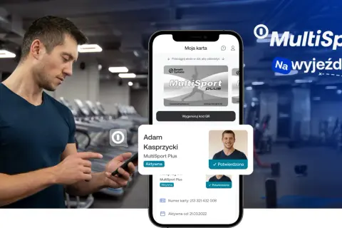 Mężczyzna w siłowni korzysta z telefonu z aplikacją MultiSport.