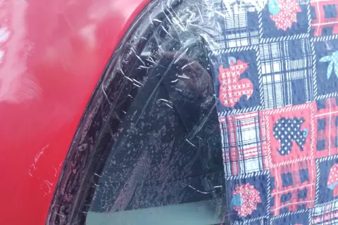 Czerwony lakier samochodu z folią ochronną i kolorową tkaniną z motywem zwierząt. To dowód, że lakierowanie samochodu zrób to sam może być kreatywne.