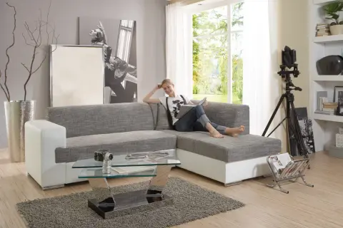 Ein modernes Wohnzimmer mit einer Frau auf dem Sofa, die liest. Der Glastisch davor ist nicht sehr hoch, perfekt für Snacks.