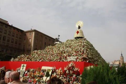 Ofrenda de flores gigante para el programa de fiestas del Pilar, con la Virgen en la cima.