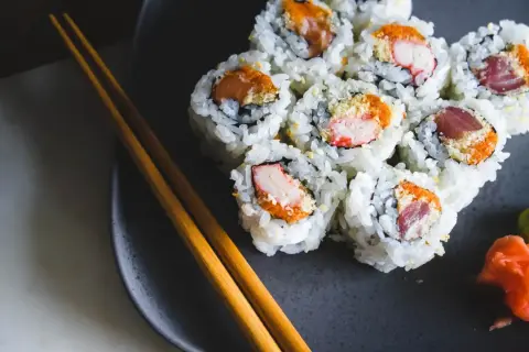 Talerz z sushi, pałeczki i dodatki. Zastanawiasz się nad sushi kcal? Smacznego!