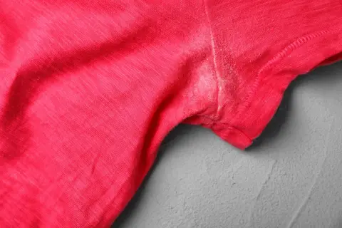 Rotes T-Shirt mit hartnäckigen Deo-Flecken unter dem Arm. Tipps zum Deoflecken entfernen gesucht?