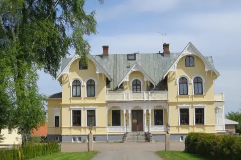 Gult hus med vita detaljer, en vacker entré och grönska. Perfekt för en Scandic Billingen frukost.