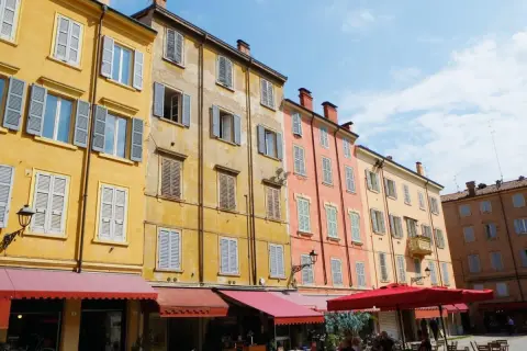Färgglada hus med persienner i Emilia-Romagna. En solig dag på en italiensk piazza.