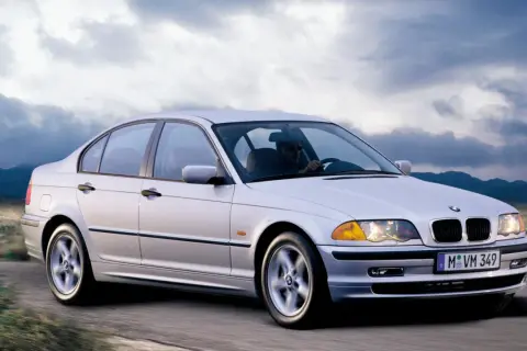 Un BMW 320d E46 150cv Stage 2 plateado circula por una carretera rural.
