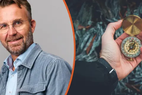Man med glasögon och kompass i handen, symbol för att navigera i en VUCA-värld.