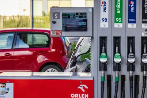 Dystrybutor paliwa Orlen z różnymi rodzajami paliwa, w tym Verva i Efecta. W tle czerwony samochód.