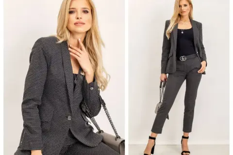 Elegancki damski casual dress code: kobieta w grafitowym garniturze w drobny wzór, z czarną bluzką i torebką.