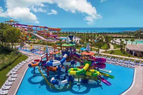 Kolorowy aquapark z mnóstwem zjeżdżalni i basenów, idealny na wakacje all inclusive w Turcji.