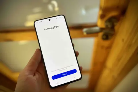 Dłoń trzyma smartfon z ekranem logowania Samsung Pass. Dowiedz się, samsung pass co to jest i jak działa.