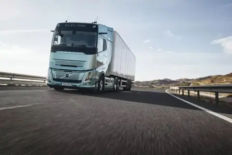 Un camion électrique Volvo roule sur une route ensoleillée, symbolisant l'autonomie et l'avenir du transport.
