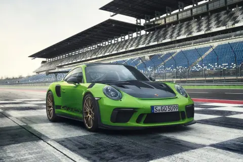Zielony Porsche 911 GT3 RS na torze wyścigowym. Sprawdź porsche 911 gt3 rs cena i specyfikację.