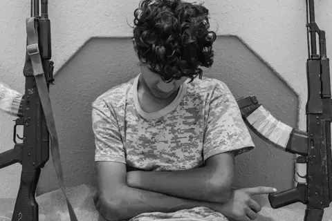 Ragazzo con fucili, uno scatto intenso di Micalizzi fotografo.