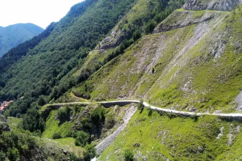 Strada tortuosa che si snoda tra le montagne, parte delle tappe della Via Vandelli.