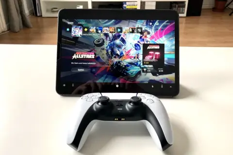 PS5 Controller mit Handy verbinden: Ein DualSense-Controller liegt vor einem Tablet, das das Spiel "Destruction AllStars" anzeigt.