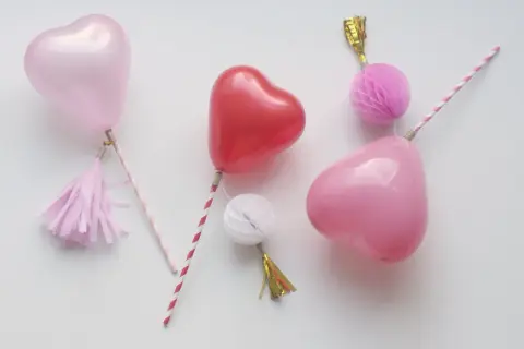 Balony w kształcie serc na patyczkach z ozdobami.