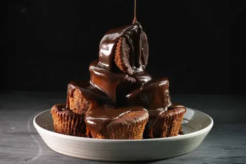 En stapel chokladmuffins, rikligt täckta med varm chokladsås. Ett perfekt sticky toffee pudding recept för fikat.