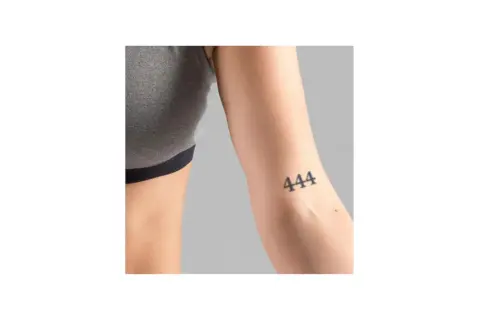 Ein Unterarm mit einem Tattoo der Zahl 444. Dieses engelszahlen tattoo bedeutungsvolle Symbol steht für Schutz und göttliche Führung.