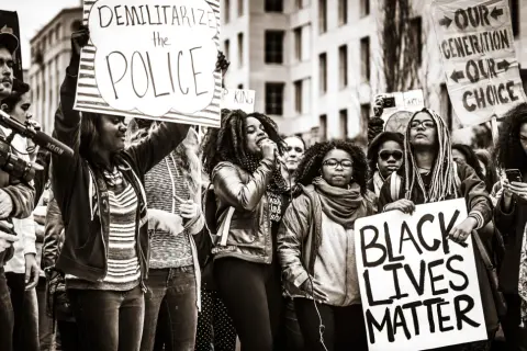 Menschen demonstrieren für Gleichheit. Ein Schild verkündet "Black Lives Matter", was die Bedeutung von BLM unterstreicht.