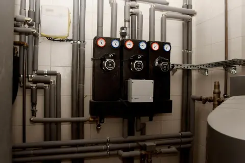 System pomp i manometrów, kluczowy dla prawidłowego działania pieca węglowego. Jakie rury do pieca węglowego? Tutaj widzimy izolowane rury i połączenia.