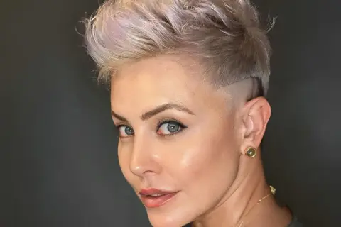 Capelli corti uomo sfumati con un ciuffo audace e un taglio moderno.