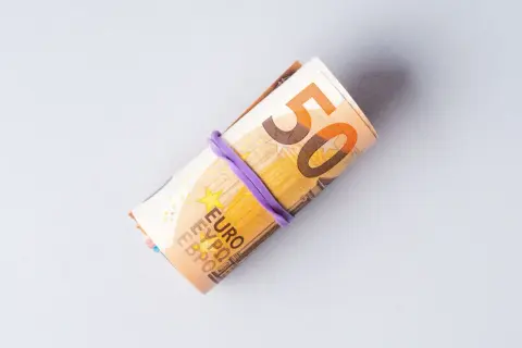 Zrolowane banknoty euro, widoczna cyfra 50. Symbolizują ceny w Niemczech i koszty życia.