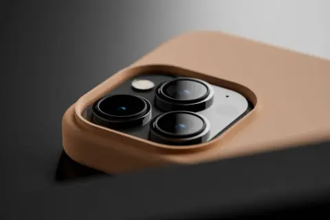 Gros plan sur le module caméra d'un smartphone, protégé par une coque en silicone TPU couleur sable.