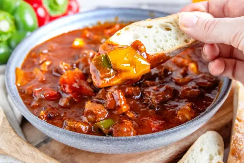 Herzhaftes Schaschliktopf Rezept: Fleischstücke und Paprika in würziger Sauce, perfekt zum Dippen mit Brot.