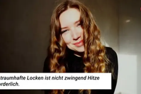 Traumhafte Hollywood Waves selber machen: Junge Frau mit voluminösen, welligen Haaren lächelt.