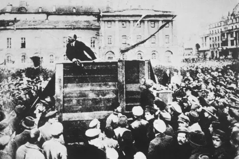 Une foule écoute un orateur sur une estrade. Une staline photo retouchée, où l'on voit un homme seul, dominant la foule.