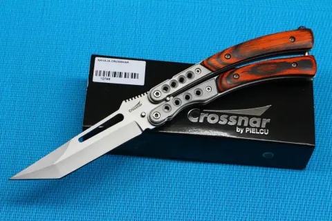Navaja Crossnar con mango de madera anaranjada y detalles plateados, lista para la acción.