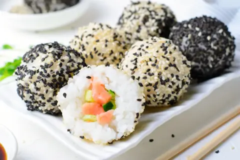 Kuleczki ryżowe z łososiem i ogórkiem, obtoczone w sezamie. Idealne składniki na sushi.